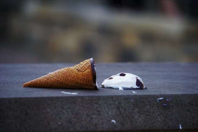 Melting ice cream cone on the ground, representing mistakes and things falling apart