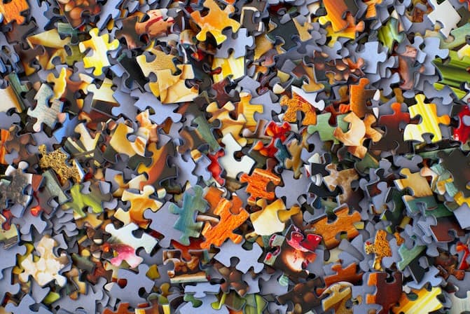 Colorful puzzle pieces scattered and coming together, representing problem-solving and finding solutions